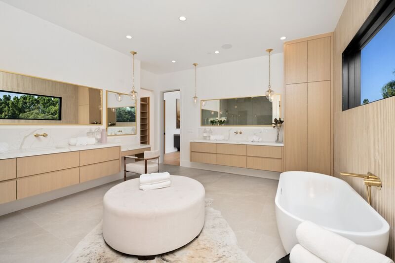 area de baño con jacuzzi en el centro y muebles de baño cafe